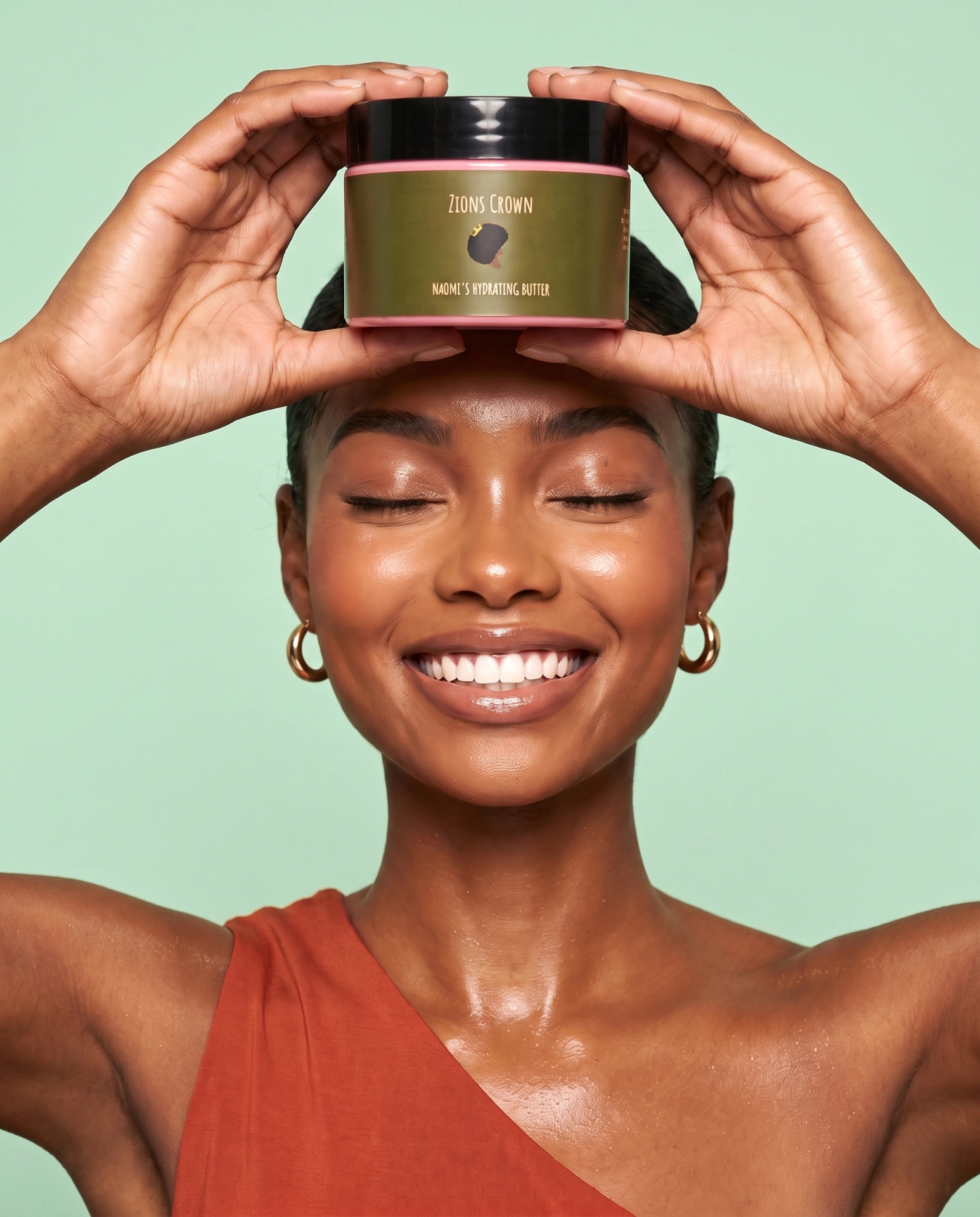 Smiling woman holding Naomi's Hydrating Hair Butter above her head