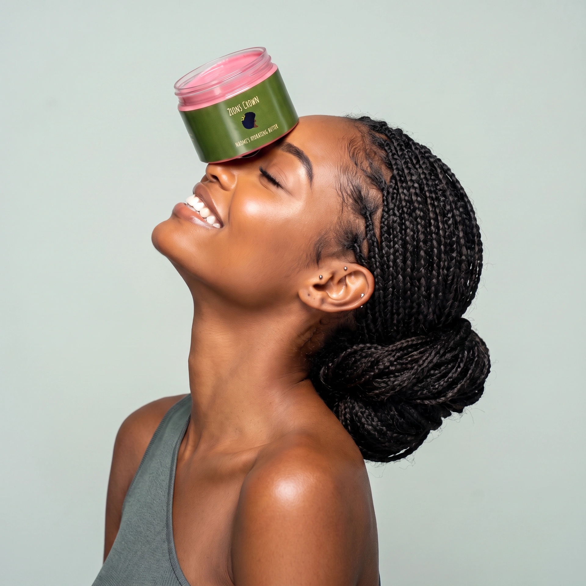 Woman with braids balancing Naomi's Hydrating Hair Butter on her forehead